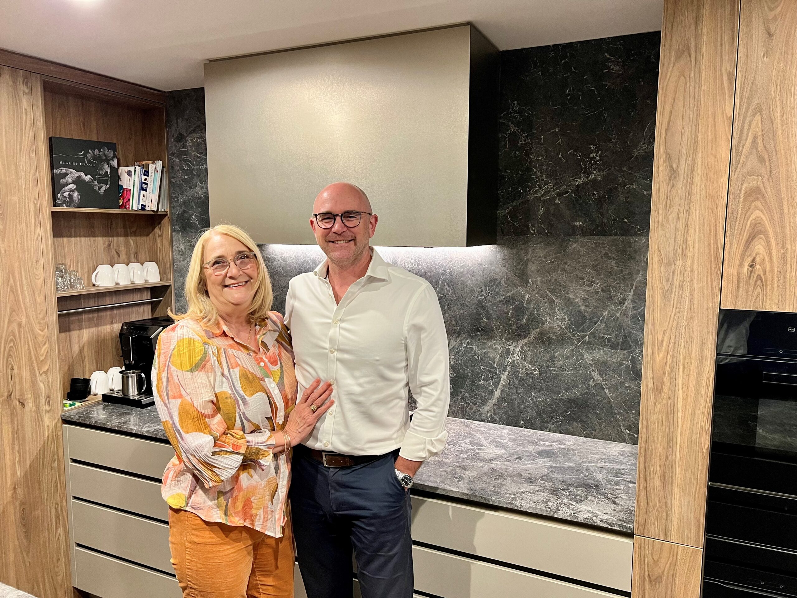 A happy couple smiling in their new bar kitchen.